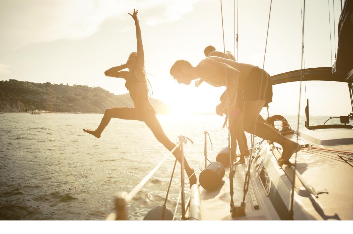 Vacanza in barca gruppo fra amici che si divertono e si tuffano